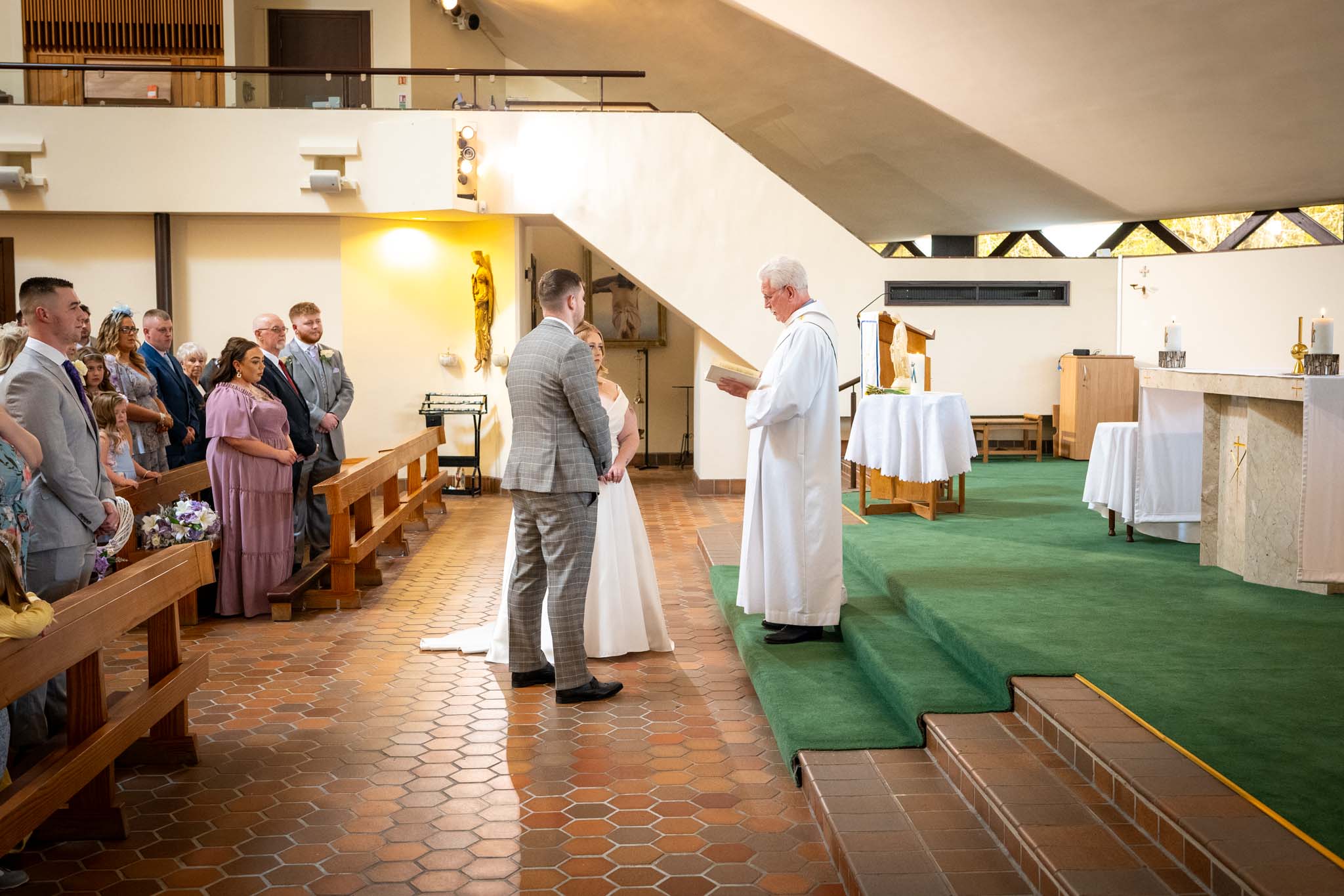 Wedding at St. John Boste Church. Couple giving vows.